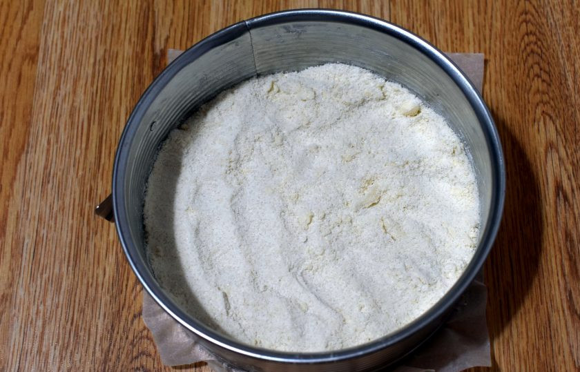 1. Этап. Насыпной пирог с творогом и яблоками: Разделите визуально крошку на три части и высыпьте одну часть в разъемную форму с проложенным пергаментом.