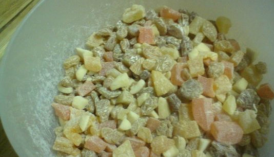 1. Этап. Кулич настоящий: Пока тесто поднимается, смешиваем в миске орехи с цукатами и изюмом. Перемешиваем их с небольшим количеством муки.