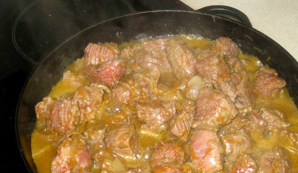 1. Этап. Тушеная говядина на сковороде: Добавляем мясо. Огонь немного увеличиваем, тушим все вместе. Затем доливаем еще стакан воды, накрываем крышкой и тушим смесь на самом тихом огне 50 минут.