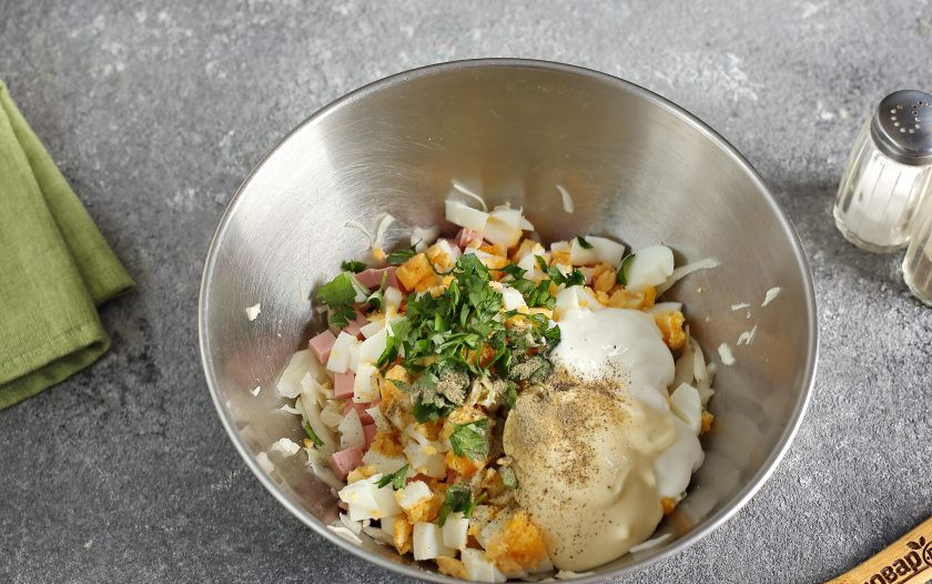 1. Этап. Салат с яйцом, капустой и колбасой: Добавьте сметану, майонез и любую свежую зелень. Салат посолите и поперчите по вкусу.