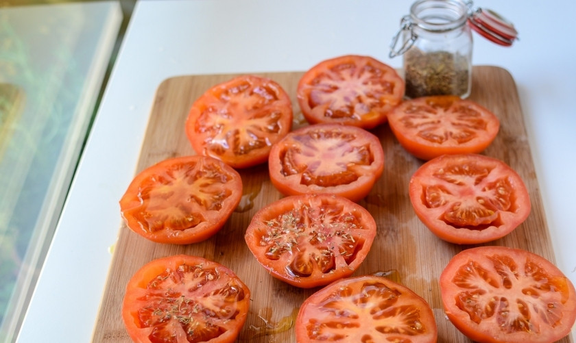 1. Этап. Запеченные томаты: Разрежьте томаты на две равные половинки. Полейте оливковым маслом, посыпьте приправами, поперчите (посолите по вкусу).