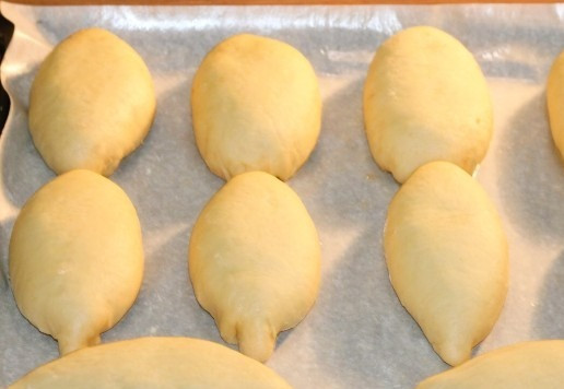 1. Этап. Пирожки с яблочной начинкой: 17. Выкладываем пироги на противень, на небольшом расстоянии друг от друга. Противень предварительно застилаем пекарской бумагой и смазываем маслом (растительным или сливочным). Накрываем противень пленкой, полотенцем и оставляем в теплом месте минут на 30 иди до увеличения пирогов в 2 раза.