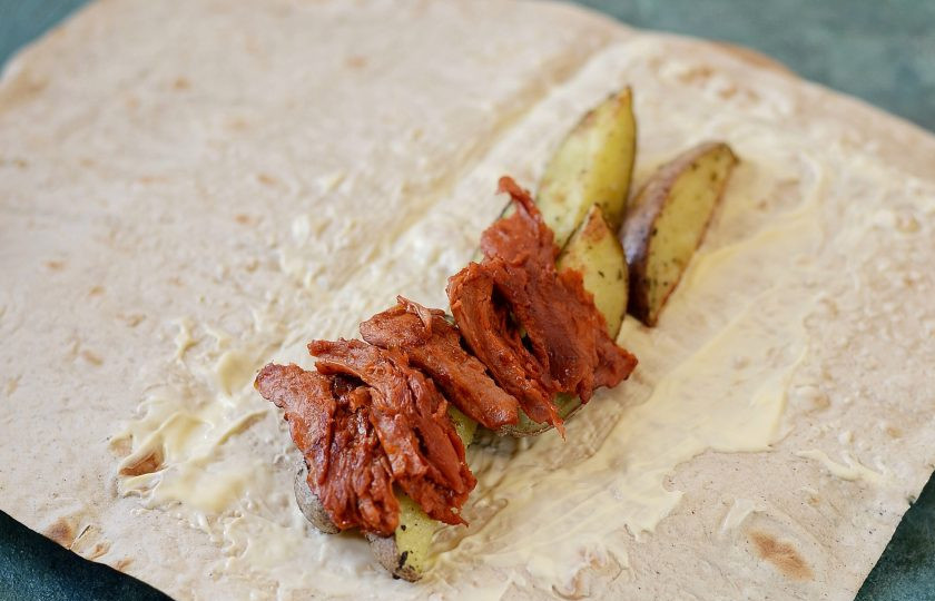 1. Этап. Шаурма с соевым мясом: Смажьте одну половину лаваша майонезом. Выложите картофель и соевое мясо.