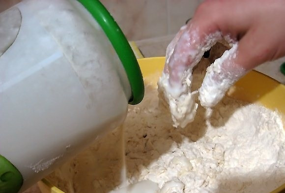 1. Этап. Хинкали на кефире: В большую миску просейте муку. Добавьте туда немного соды (не гасите), немного соли, сугубо по вашему вкусу. Перемешайте и влейте туда кефир или скисшее молоко. Кефир я обычно лью на глаз, до тех пор, пока тесто не станет крутым и однородным. Перемешайте тесто руками, оно должно быть гладким и эластичным.