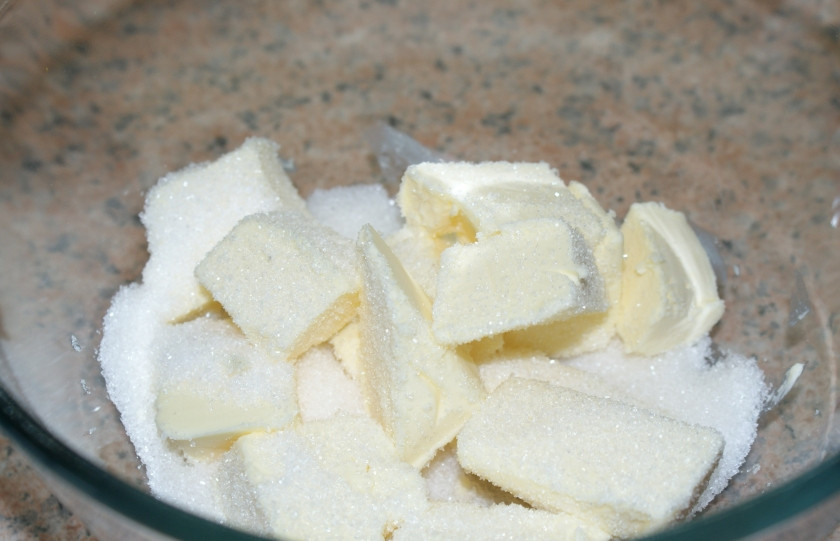 1. Этап. Творожная ватрушка из песочного теста: Включите духовку, дайте ей разогреться до 180 градусов. Мягкое сливочное масло разрежьте на кубики. Добавьте муку, сахар и соду.