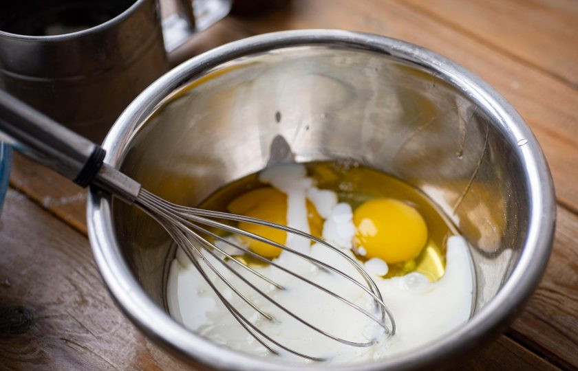 1. Этап. Хворост в духовке на кефире: В отдельную миску вбейте яйца и залейте кефир. Перемешайте до получения однородной смеси.