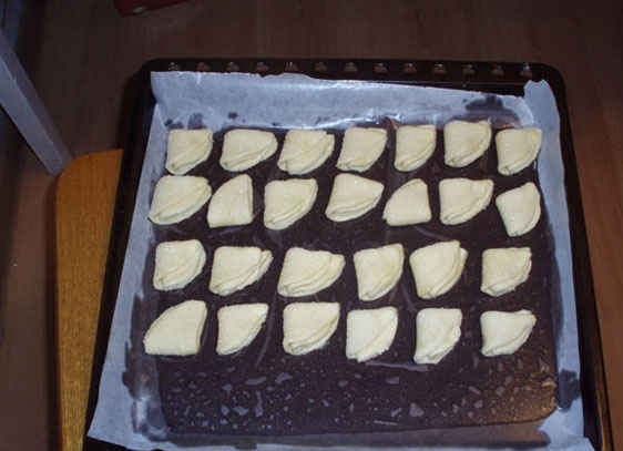 1. Этап. Творожные ушки: 4. Так проделываем с каждым кружочком и складываем их на противень с пергаментом, что смазан немного маслом.