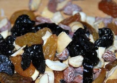 1. Этап. Бисквит с сухофруктами: Сухофрукты вымоем и подсушим. Крупные орехи, курагу и чернослив измельчим. Затем добавим к ним крахмал и перемешаем.