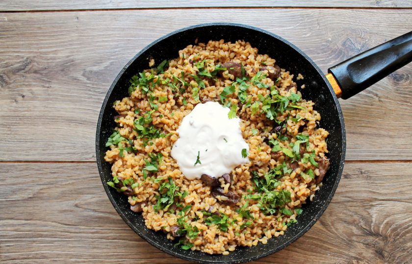 1. Этап. Булгур с куриными сердечками: Добавьте сметану, мелко порезанную петрушку и перемешайте. Готовьте еще 2 минуты и снимите с огня.