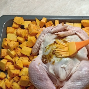 1. Этап. Курица, запеченная по-особому: Кожу вокруг отверстия собрать и закрыть, скалывая с помощью зубочистки. Ножки и крылья связать бечевкой. Курицу выложить в форму для запекания, заранее смазанную растительным маслом и хорошо растереть ее приготовленным соусом.