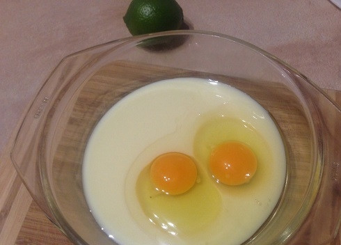 1. Этап. Лаймовые пончики на сгущенном молоке: Наливаем в миску сгущенку и добавляем яйца.