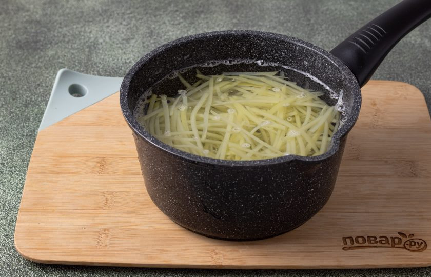 1. Этап. Овощной салат Дыхание Дракона: Картофель очистите от кожуры и натрите на терке для моркови по-корейски. Хорошенько промойте тертый картофель до прозрачной воды. Затем отварите в кипящей воде 4 минуты. Откиньте на сито и дайте стечь лишней жидкости.