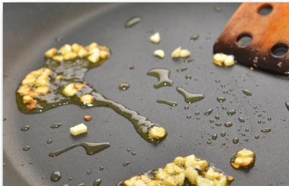 1. Этап. Салат из шпината, изюма и кедровых орешков: Слегка обжариваем чеснок в оливковом масле.