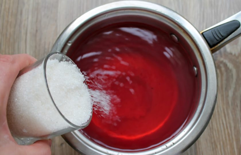 1. Этап. Компот из яблок и терна на зиму: Слейте воду из банки в кастрюлю и всыпьте сахар. Доведите до кипения на среднем огне.