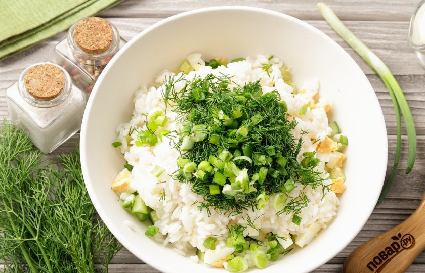 1. Этап. Салат с рисом, яйцом и майонезом: Добавьте к огурцам с яйцами рис и рубленную зелень. Зелень можете взять любую на свой вкус, у меня петрушка, укроп и зелёный лук.