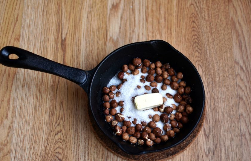 1. Этап. Песочный пирог с орехами: Стакан фундука выложите на сковороду и подсушите до появления приятного аромата. Затем добавьте 2-3 ложки сахара. Положите небольшой кусочек сливочного масла (20 грамм). Поставьте на огонь и помешивая расплавьте сахар до карамели. Орехи должны равномерно покрыться карамельной глазурью. Выложите готовые орехи в карамели на силиконовый коврик, разровняйте, стараясь, чтобы орехи лежали россыпью. Остудите.