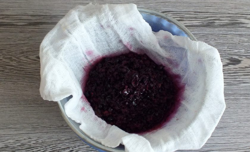 1. Этап. Ликёр из черноплодной рябины: По истечении времени ликёр процедите через сито, застеленное несколькими слоями марли. Жмых отожмите. Повторите процеживание.