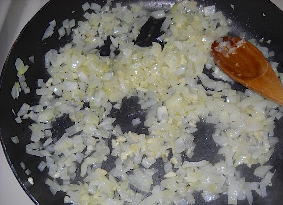 1. Этап. Постная долма (без мяса): 1. Нарежьте кубиком лук, измельчите чеснок. Разогрейте сковороду с 2 столовыми ложками растительного масла, добавьте лук, а спустя 4-5 минут еще выложите чеснок.