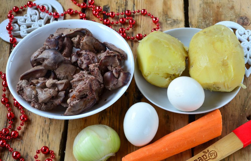 1. Этап. Новогодний салат в Год Собаки: Подготовьте все необходимые ингредиенты. Куриную печень заранее отварите в подсоленной воде. Картофель отварите до готовности, а яйца отварите вкрутую.