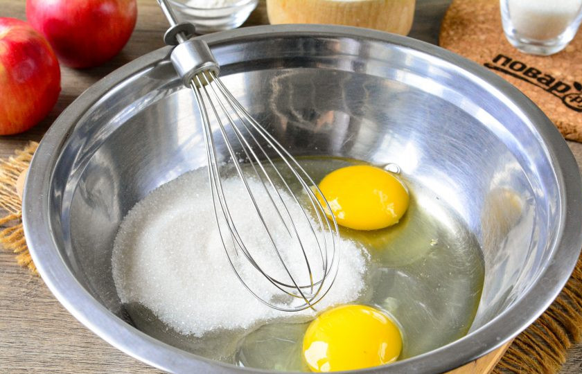 1. Этап. Ванильный кекс с яблоками: В миску вбейте куриные яйца, всыпьте туда обычный и ванильный сахар.