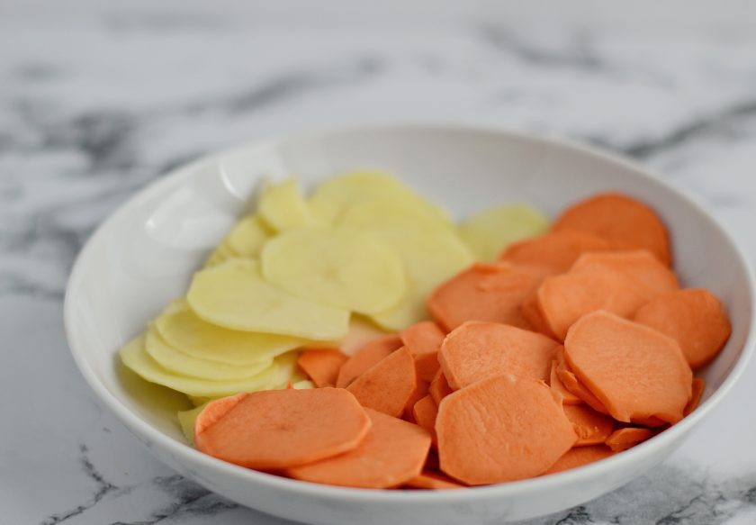 1. Этап. Запеканка с бататом: Очистите батат и картофель от кожуры, затем нарежьте на кружочки толщиной 2-3 мм.