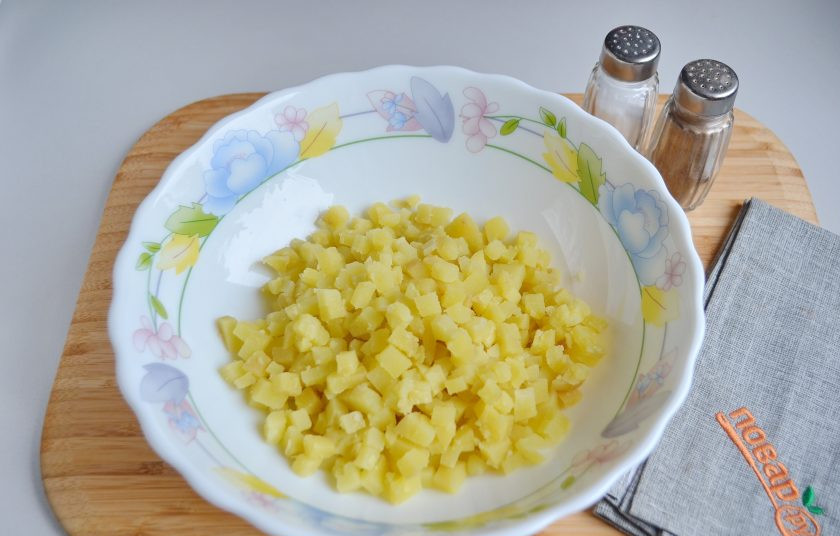 1. Этап. Русский салат Оливье: 2. Очищенный картофель порежьте маленькими кубиками.