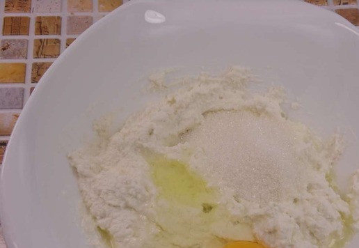 1. Этап. Кокосовые рикоттники с рисовой полентой: В полученную массу добавить куриное яйцо и сахар, перемешать.