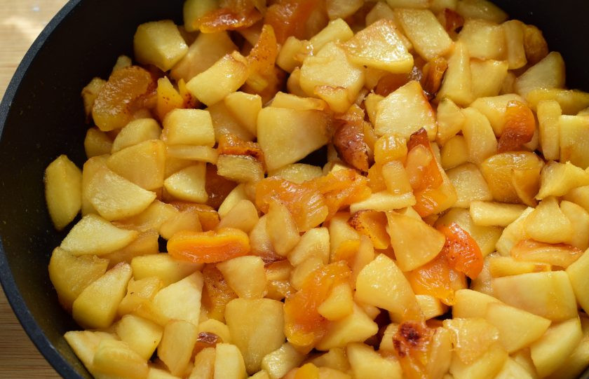 1. Этап. Шарлотка с курагой и яблоками: Добавьте кусочки фруктов, перемешайте и обжаривайте до тех пор, пока они не покроются полностью растопленной карамелью.