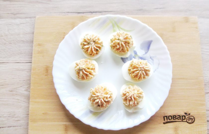 1. Этап. Яйца фаршированные крабовыми палочками и сыром: Половинки белков наполните начинкой при помощи чайной ложки. Либо отсадите с помощью кулинарного мешка и насадки.