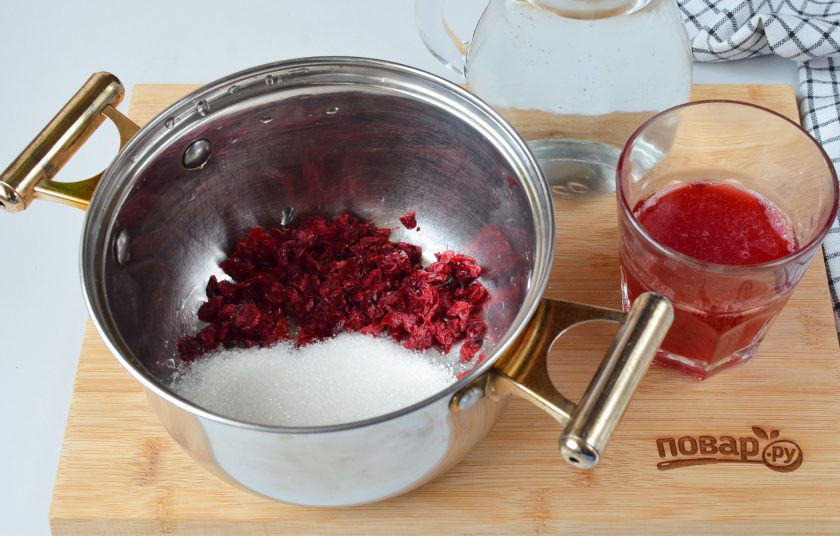 1. Этап. Морс клюквенный: Отцедите с помощью марли сок из ягод. Стаканчик с соком уберите в холодильник. Жмых выложите в кастрюлю, туда же добавьте сахар и воду.