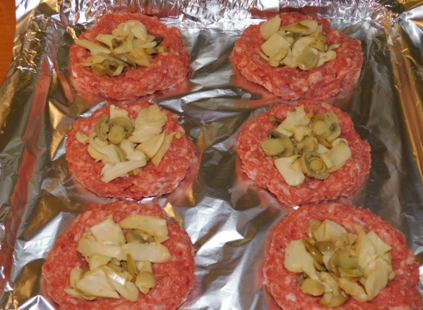 1. Этап. Мясные гнезда в беконе: Выложите в центр немного нарезанных шампиньонов.