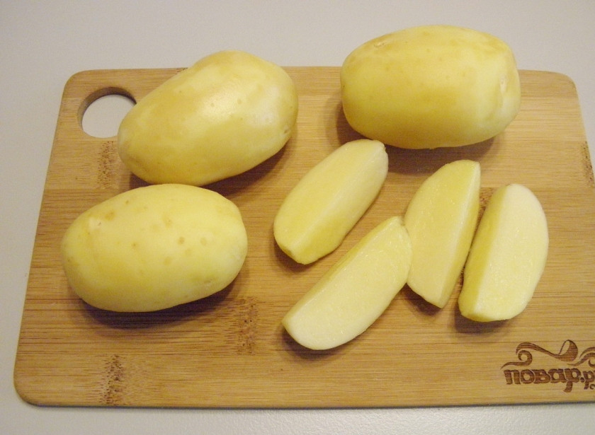 1. Этап. Картошка по-деревенски в духовке: Картофель тщательно вымойте, снимите молодую кожуру. Обсушите картофель с помощью вафельного полотенечка, он должен быть сухим. Порежьте на 4-6-8 частей, в зависимости от размера картофелины. Но желательно, чтобы дольки были одного размера.