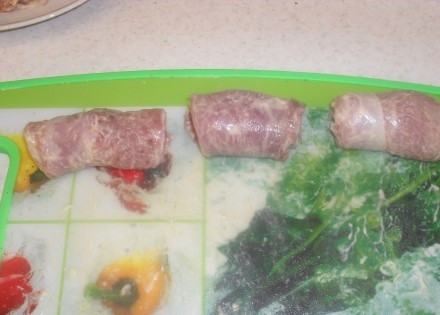 1. Этап. Рулетики из индейки в мультиварке: После того как отбили куски мяса, положите их опять на досточку, начните добавлять специи и начинку. Посолите, поперчите, посыпьте мелко порубленными грецкими орехами, на каждый кусок положите немного тёртого сыра. После этого заверните мясо рулетиками.