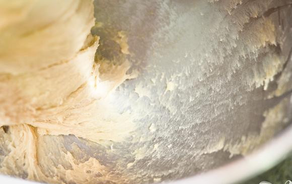 1. Этап. Хлеб с корицей: 3. Добавить молочную смесь и яичную смесь и взбить миксером на низкой скорости. Увеличить скорость до средней и продолжать взбивать до однородности. После этого увеличить скорость до высокой и взбивать 10 минут, пока тесто не станет гладким и эластичным. Если через 5 минут тесто будет еще липким, добавьте еще муки.