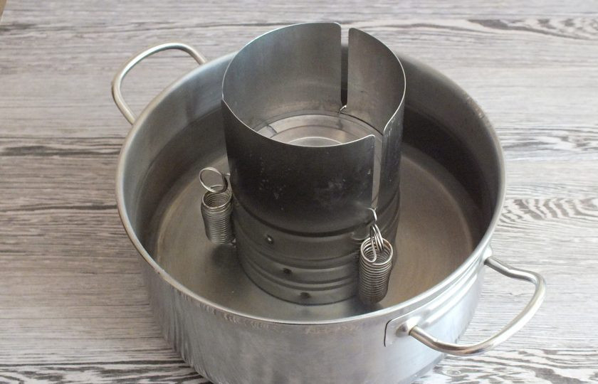 1. Этап. Грудинка в ветчиннице: Поставьте ветчинницу в кастрюлю с водой. Уровень воды должен быть чуть выше уровня закрываемой крышки ветчинницы. Поставьте кастрюлю на огонь. Варите при температуре 80-90 градусов, не допуская кипения, в течение 2 часов.