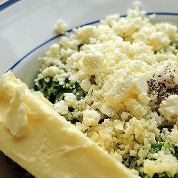 1. Этап. Хлеб с артишоками, сыром и чесноком: 4. Добавить раскрошенный сыр Фета и размягченное сливочное масло. Приправить солью и перцем по вкусу. Тщательно перемешать до получения однородной консистенции.