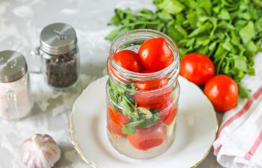 1. Этап. Десертные помидоры: Промойте в воде помидоры и веточки сельдерея, банку. Распределите овощи и зелень в емкость до верха. Очистите чесночные зубчики от шелухи, промойте в воде и вложите между томатами в банку.