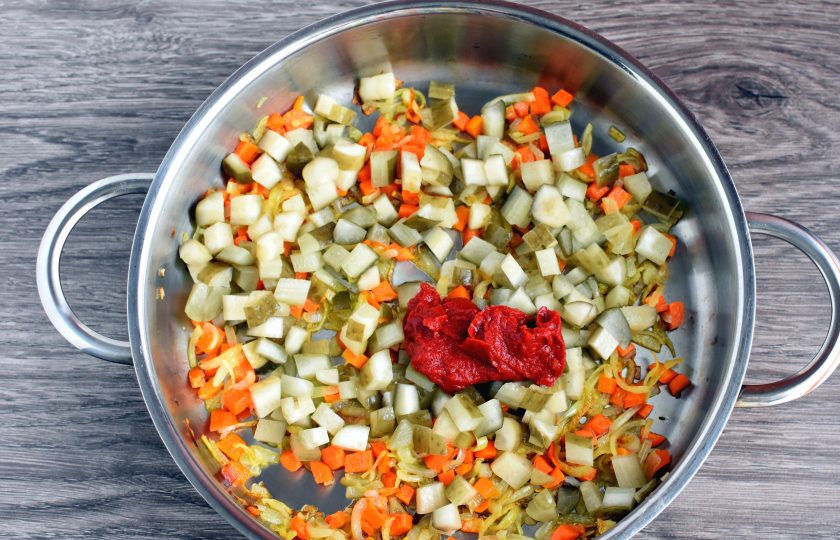 1. Этап. Рассольник с копченостями: Затем добавьте соленые огурцы, нарезанные кубиками и томатную пасту. Обжарьте все вместе еще 3 минуты. Затем влейте немного рассола и потушите 5 минут.