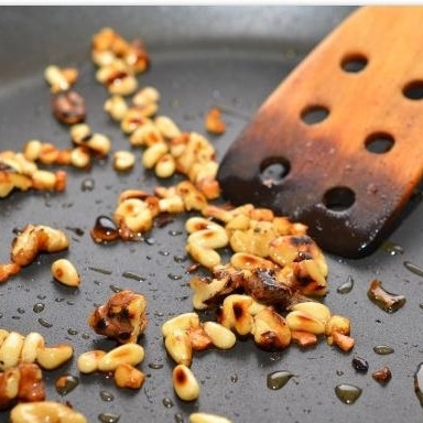 1. Этап. Салат из шпината, изюма и кедровых орешков: Добавляем в сковороду орешки, перемешиваем, чуть-чуть поджариваем.