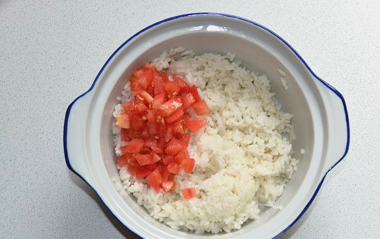 1. Этап. Фаршированный кальмар на гриле: В отваренный рис добавьте нарезанный кубиками помидор.