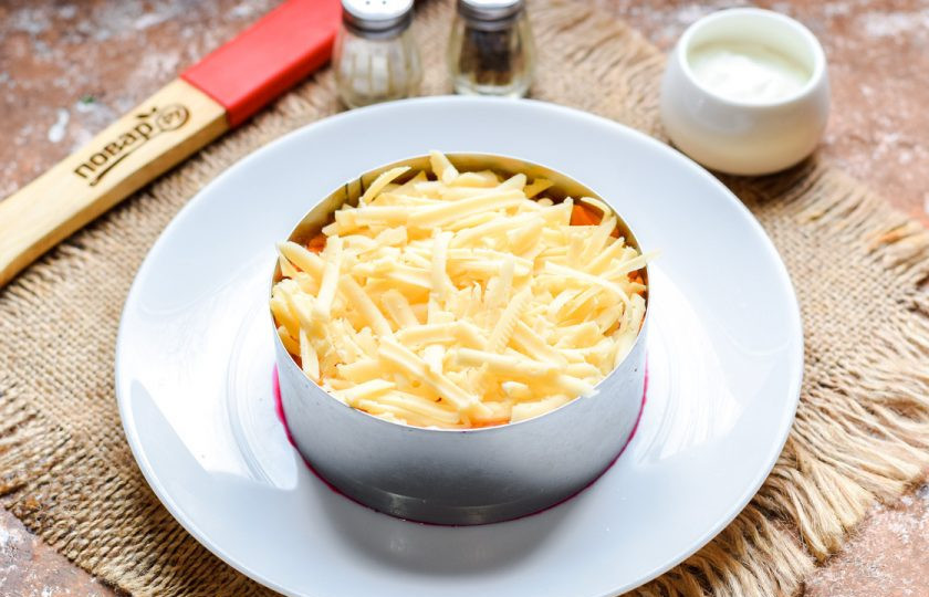 1. Этап. Салат Чингисхан со свеклой: Следующим слоем выложите твердый сыр, натертый средней стружкой.