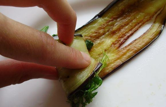 1. Этап. Жареные баклажаны с чесноком: Теперь главное - берем обжаренные баклажаны, кладем на краешек немного начинки из чеснока и зелени и заворачиваем в рулетик - так, как показано на фото.