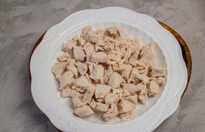 1. Этап. Салат Екатерина Мудрая: На плоское блюдо выложите первым слоем нарезанное небольшим кубиком куриное филе.