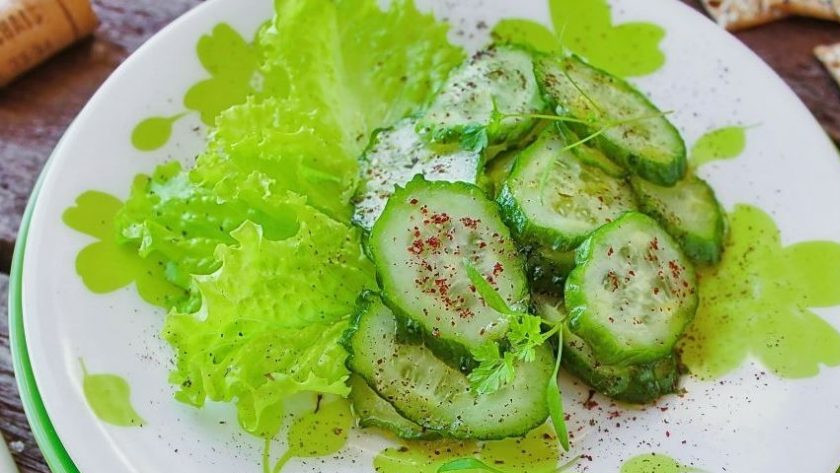 1. Этап. Быстрый легкий салат: Вымойте салат и разберите его на листья. Выложите их на тарелку, а поверх положите нарезанные огурцы с заправкой. Присыпьте огурцы молотым сумахом и сушеной мятой, затем украсьте веточками зеленой петрушки.