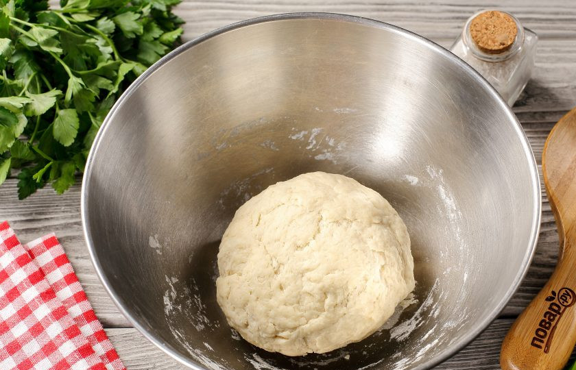 1. Этап. Заварные лепёшки с сыром и зеленью: Затем частями подсыпая оставшуюся муку, замесите эластичное тесто. Соберите его в шар, накройте миску полотенцем и дайте полежать 20 минут.