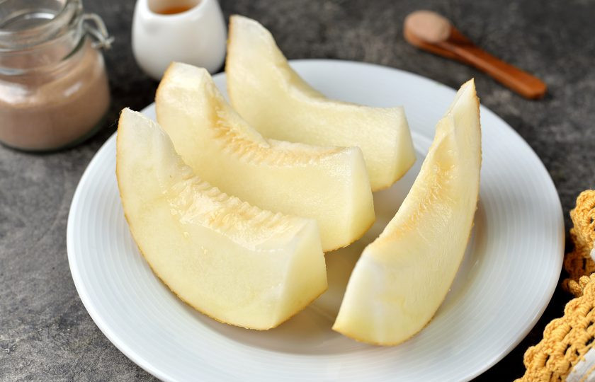 1. Этап. Запеченная дыня в духовке: Прежде чем разрезать дыню, ее нужно помыть под проточной водой и вытереть насухо. Затем разрежьте ее на две части, выскоблите семечки, мякоть вместе с кожурой нарежьте на крупные дольки.