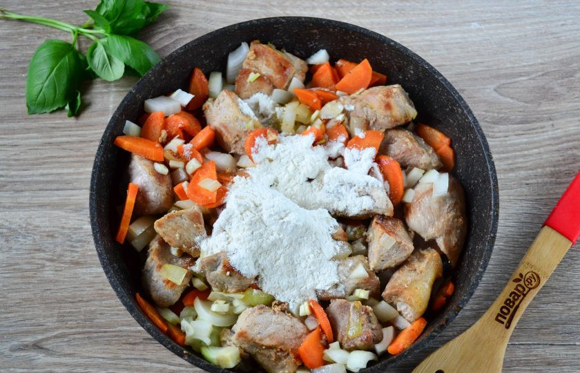 1. Этап. Гуляш из свинины с морковью и луком: Затем добавьте соль и муку. Хорошенько перемешайте.