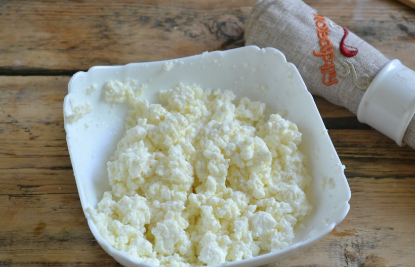 1. Этап. Ватрушка с творогом: Тем временем подготовьте начинку. Белок отделите от желтка и добавьте к творогу. Желток оставьте для смазки ватрушек. Также в начинку добавьте сахар, тщательно перемешайте ложкой. Можно также добавить отпаренный изюм или другие сухофрукты.