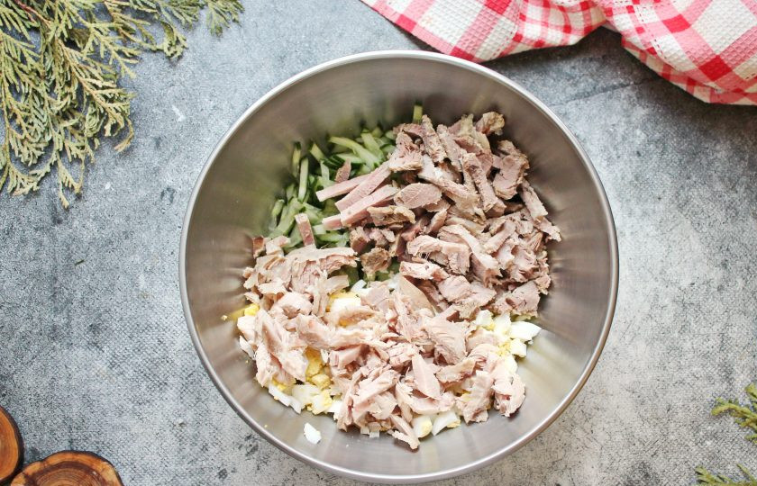 1. Этап. Салат Мясное ассорти: Отварную свинину и курицу порежьте поперек волокон соломкой и выложите в салатник.