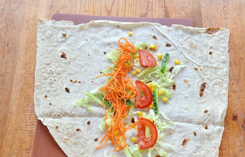 1. Этап. Шаурма на углях: Распределите ровным слоем овощи - капусту, огурец, морковь, немного кукурузы, помидор.